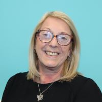 Julie Eastlake smiling with glasses, blonde hair and black top