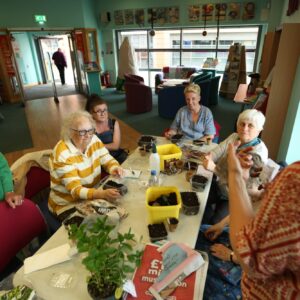 IMG_7924 Group of people planting seeds sat at table